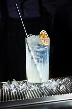 Refreshing Tom Collins cocktail garnished with citrus on the rocks
