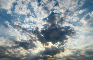 Captivating play of light through dramatic clouds at sunset over a tranquil landscape