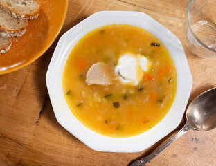 Delicious traditional rassolnik soup with sour pickles and pearl barley served in bowl