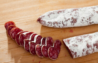 Fuet, traditional spanish dry cured sausage on wooden table