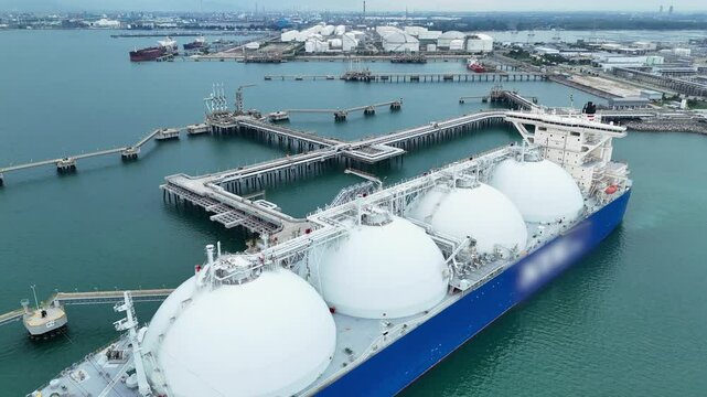 LNG (Liquified Natural Gas) tanker anchored in Gas terminal gas tanks for storage. Oil Crude Gas Tanker Ship. LPG at Tanker Bay Petroleum Chemical or Methane freighter export import transportation