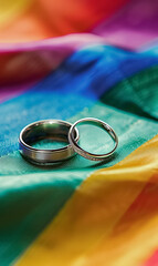 two golden wedding rings on rainbow lgbt background, gay and lgbtq marriage concept, equality, human rights, tolerance and acceptance