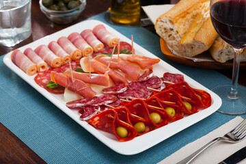 Appetizer of various types of Spanish sausages on platter served to wine