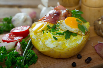 Appetizing baked potato filling with cheese, eggs and herbs served on cutting board