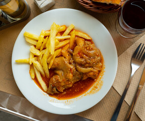 Spicy pork trotters stewed in tomato gravy served with side dish of crispy French fries..