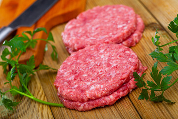 Cooking ingredients, raw burger cutlets on wooden table