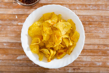 Appetizing chips with a glass of beer on a wooden surface