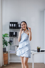 Cheerful beautiful Asian woman freelancer making telephone call in the office workplace,
