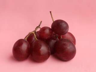 Close-up of a pile of red grapes isolated on pink background