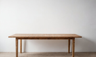 A wooden table sits in front of a white wall