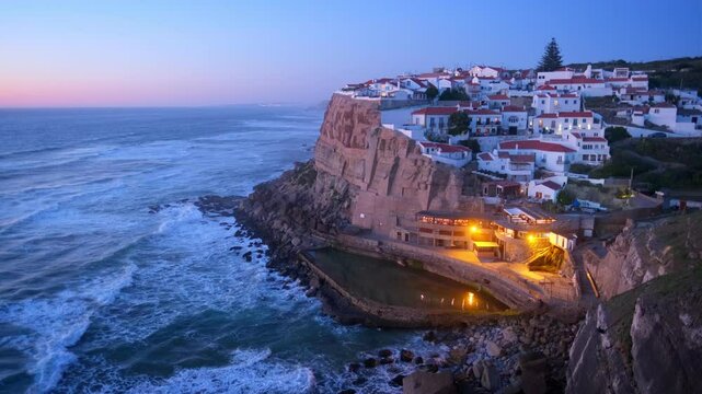 Scenic view of the seaside Azenhas do Mar fishing village on cliff on Atlantic ocean coast, Portugal illuminated in evening twilight