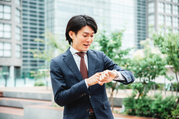 時計を見て焦るビジネスマン（遅刻）
