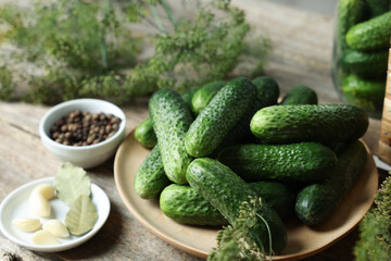 Fresh cucumbers and spices on wooden table, closeup. Preparation for pickling