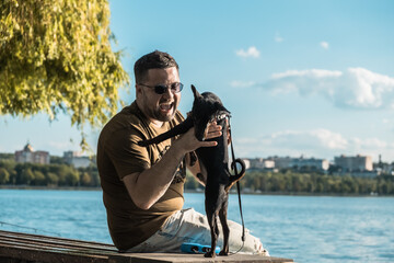 The dog jumps up to the owner.A funny dog stands on its hind legs.