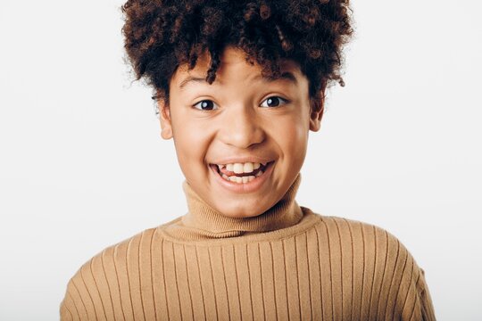 Portrait of a surprised young african american boy with mouth open expressing shock on a plain white background