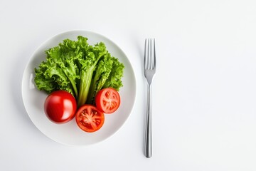 A white plate with lettuce, two tomatoes, and a fork on a white background.