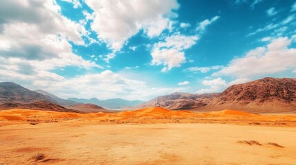 Naklejka premium A vast desert landscape under a blue sky with clouds and mountains in the background.