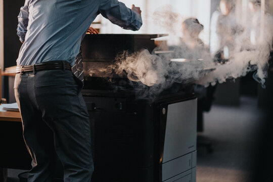 Close up of man hitting broken printer 