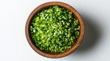 75.Overhead view of a wooden bowl filled with finely chopped spring onions, isolated on a white background. The chopped green onions are evenly spread within the bowl, their vivid color standing out