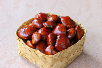 Obraz premium Dogfruit (Archidendron pauciflorum) an Indonesia commonly called djenkol, jengkol or jering on wooden woven container. Food Ingredients