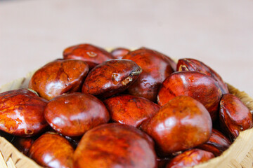 Dogfruit (Archidendron pauciflorum) an Indonesia commonly called djenkol, jengkol or jering on wooden woven container. Food Ingredients