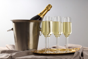 A bottle of champagne with glasses on a light background
