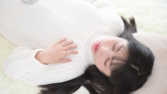 仰向けで目を閉じる女性　お昼寝や睡眠のイメージの動画