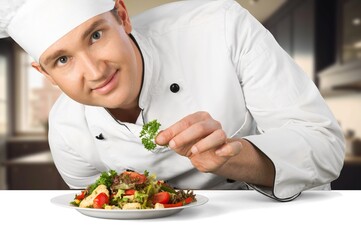 Man chef with plate cooking in kitchen