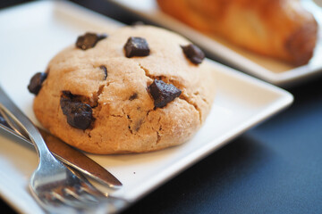 A Freshly Baked Chocolate Chip Cookie that is Perfectly Presented on an Elegant Plate for Enjoyment