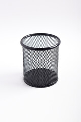 Box of colored pencils isolated on white background. Empty black basket Pen holder. Close up