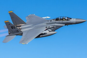 American fighter jet performing an aerial maneuver in a clear blue sky