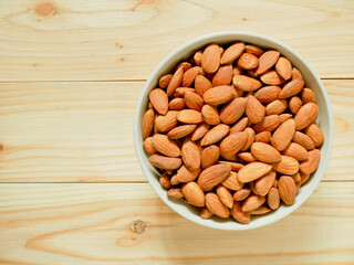 Almonds in a bowl on wooden table