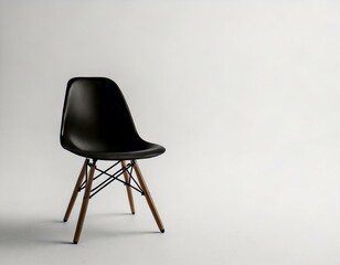 A minimalist black chair with wooden legs, set against a light gray background, emphasizing modern design and simplicity.