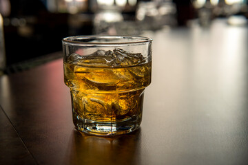 Glass of whiskey on ice at the bar counter