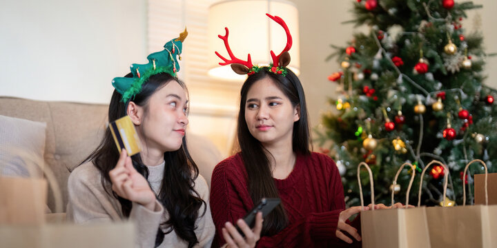 Lesbian Couple Enjoying Christmas Shopping with Credit Card and Smartphone Interaction