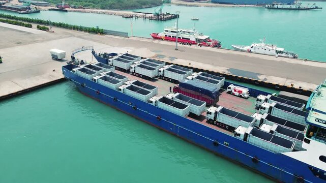 The truck was loading into a car carrier ship. Car ferry leaving docks fully loaded.