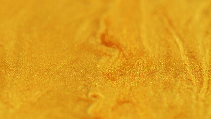 Glitter flood wave. Splashing drops. Blur golden yellow color shimmering particles glowing transparent liquid flow abstract modern art background.