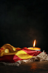 Spanish flag with candlelight: symbol of remembrance and solitude. Vertical banner. Copy space. National Day of Spain. Spanish Constitution Day