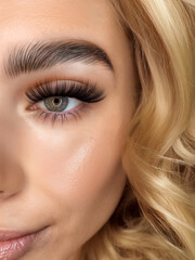 Fototapeta premium Close-Up of Blonde Model with Fluffy Classic Lash Extensions and Defined Brows