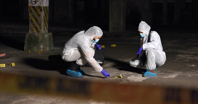 Crime scene, team or forensics at night with swab, evidence or DNA sample clue in abandoned warehouse. CSI people, hazmat suit or investigation in spotlight for legal service, inspection or pathology