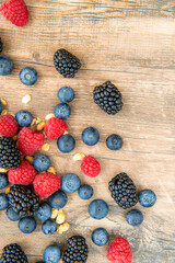 Close-up on mix berries: blackberries, blueberries, raspberries, acorns isolated on a wooden table