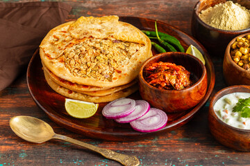 Sattu paratha, a nutritious flatbread from Uttar Pradesh and Bihar, stuffed with roasted gram flour, served with pickle and raita.