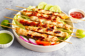Juicy chicken seekh kebabs, perfectly spiced and grilled, served with refreshing mint chutney and tangy tomato sauce. Delicious!