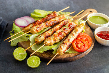Juicy chicken seekh kababs, perfectly seasoned, served with refreshing mint chutney and tangy tomato sauce for a flavorful bite.