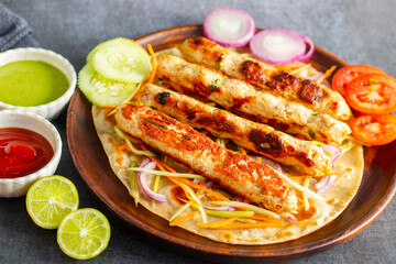 Juicy chicken seekh kababs, perfectly seasoned, served with refreshing mint chutney and tangy tomato sauce for a flavorful bite.