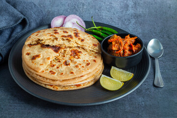 Sattu paratha, a nutritious flatbread from Uttar Pradesh and Bihar, stuffed with roasted gram flour, served with pickle and raita.