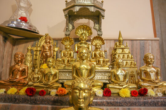 A Group of Gold colored Idols of Jain deities Lord Mahavira, Parasnath and Adinatha in Meditation posture at a Jain temple in Mysore, India.