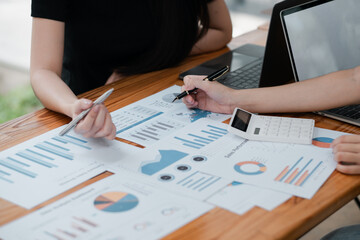 Professionals reviewing financial charts and graphs, discussing business strategies in a collaborative office environment.