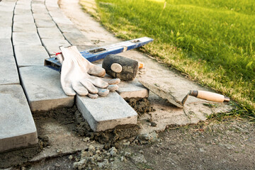 Laying paving stones on cement mortar. Laying a garden path made of tiles. Self-laying of concrete paving slabs in the courtyard of the house. do it yourself. DIY