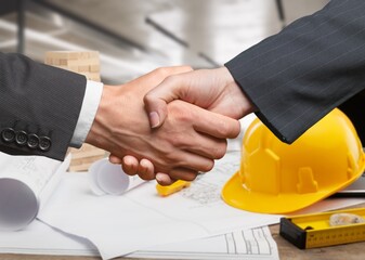 construction worker with contractor shaking hands in renovation site.